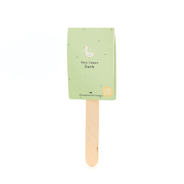 Una tarjeta verde con la ilustración de un ganso y el texto “Muchas gracias” en un palo de madera.