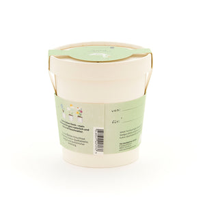 Maceta beige con etiqueta verde, inscripción e ilustraciones de plantas, parte trasera con espacio para etiquetar "desde" y "para".