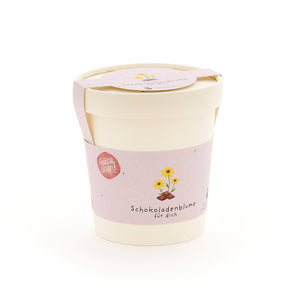 Maceta con etiqueta rosa que dice “Flor de chocolate para ti” y presenta un dibujo de una flor sobre un trozo de chocolate.