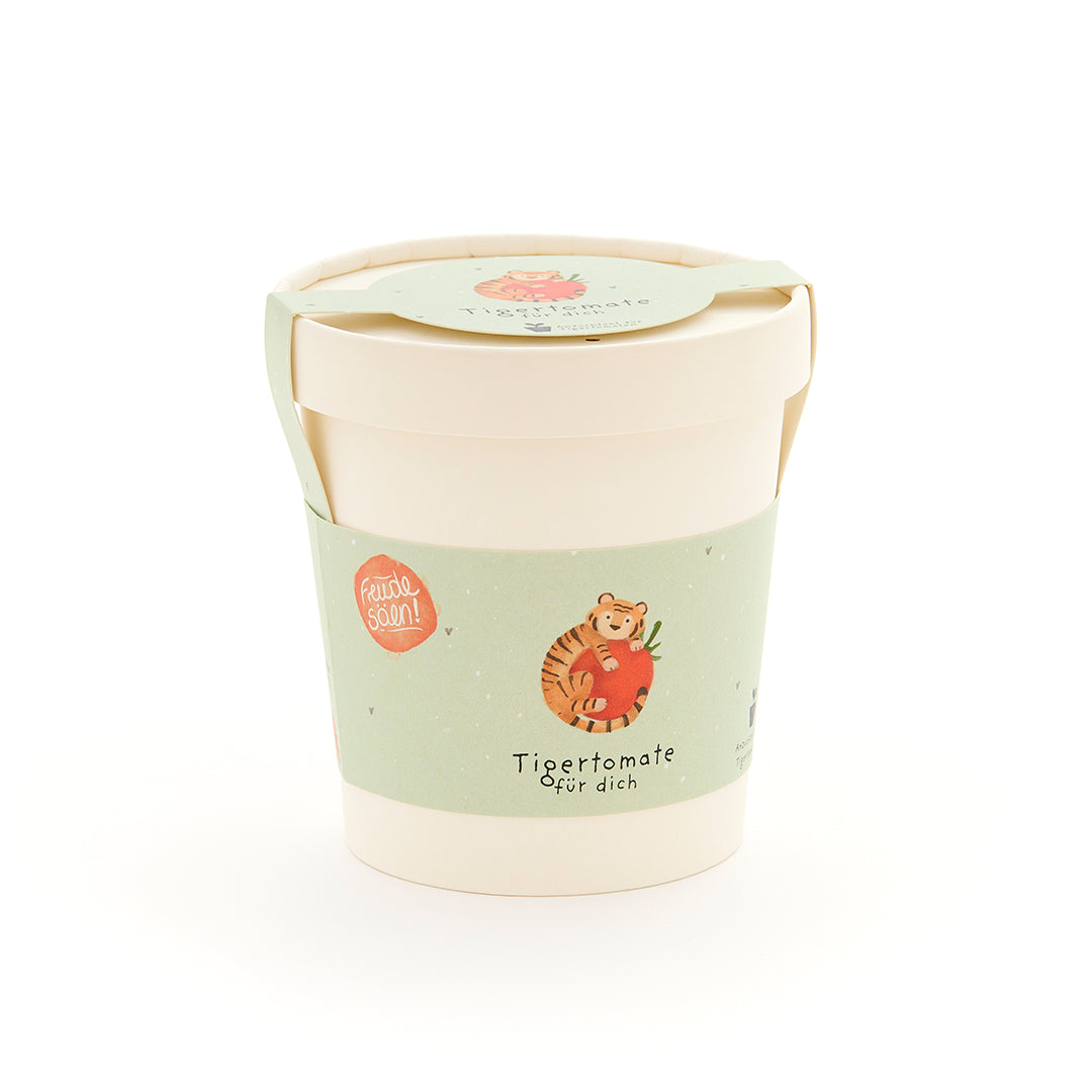 Taza con etiqueta verde que representa un tigre con un tomate y el texto "Tomate tigre para ti".
