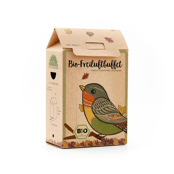 Embalaje de cartón con un colorido dibujo de un pájaro y la inscripción “Organic Outdoor Buffet”, alimento premium para pájaros silvestres y cantores.