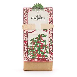 Kit de cultivo de mini huerto de chile de Die Stadtgärtner con motivo de planta rojo y verde en el embalaje.
