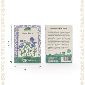 Dos paquetes de semillas de aciano con ilustración floral y descripción del producto en alemán, con dimensiones de 9 cm de alto y 6,5 cm de ancho.
