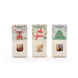Tres bolsas navideñas de dulces decoradas con ilustraciones de un reno, un muñeco de nieve y un árbol de Navidad.