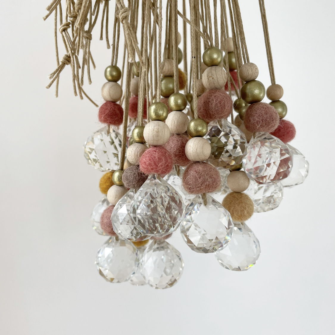 Lámpara de araña decorativa con bolas de fieltro de colores y cristales brillantes.
