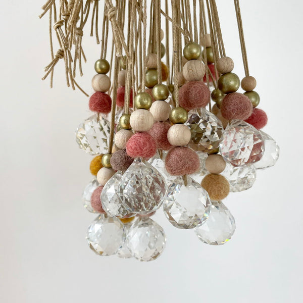 Lámpara de araña decorativa con bolas de fieltro de colores y cristales brillantes.