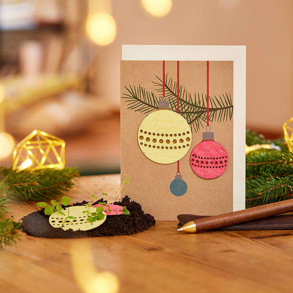 Tarjeta navideña con 3 bolas navideñas hechas de papel de semillas