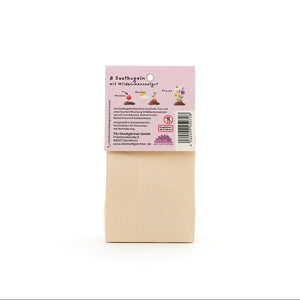 Bolsa de papel marrón con una etiqueta en alemán que describe "8 bolas de semillas con semillas de flores silvestres".