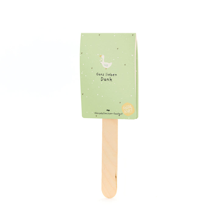 Una tarjeta verde con la ilustración de un ganso y el texto “Muchas gracias” en un palo de madera.