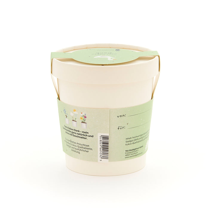 Maceta beige con etiqueta verde, inscripción e ilustraciones de plantas, parte trasera con espacio para etiquetar "desde" y "para".