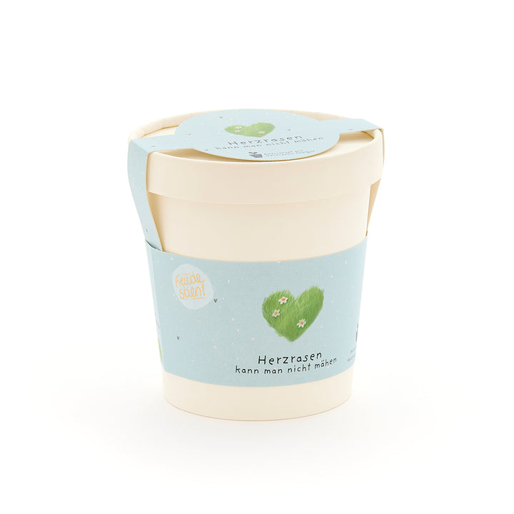 Maceta beige con una etiqueta azul claro, un corazón verde y la inscripción “No se puede cortar un corazón acelerado”.