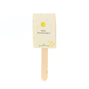 Palo de madera con una tarjeta amarilla que dice "Hola Sol" y tiene un sol encima.