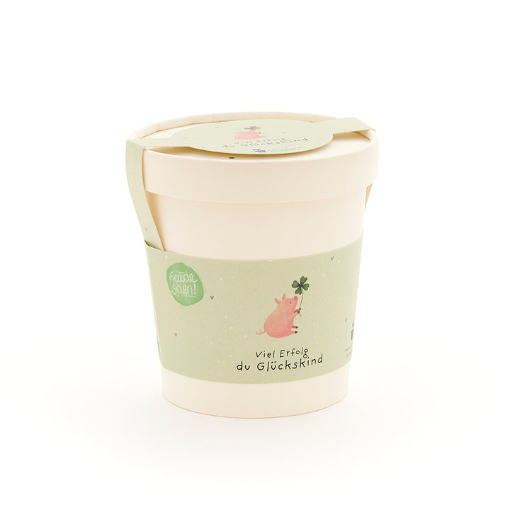 Taza con etiqueta verde que representa un cerdo con una hoja de trébol y la inscripción "Buena suerte, niño afortunado".