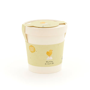Taza con etiqueta amarilla que representa un pollito y la inscripción "¡Hurra, estás aquí!"