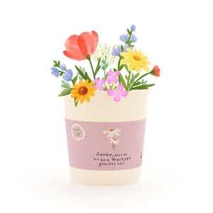 Una maceta con flores coloridas dibujadas y una cinta que dice: "Gracias por ayudarme a crecer".