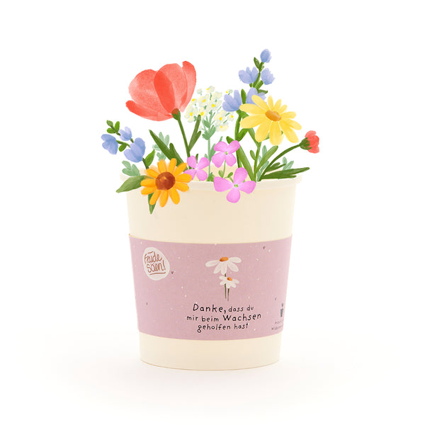 Una maceta con flores coloridas dibujadas y una cinta que dice: "Gracias por ayudarme a crecer".