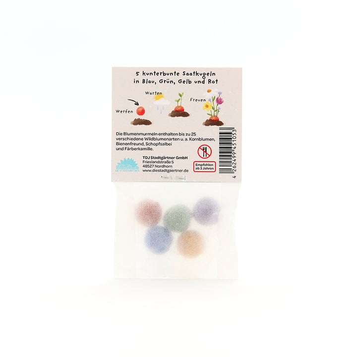 Cinco bolas de semillas de colores en un paquete transparente con instrucciones etiquetadas en alemán.
