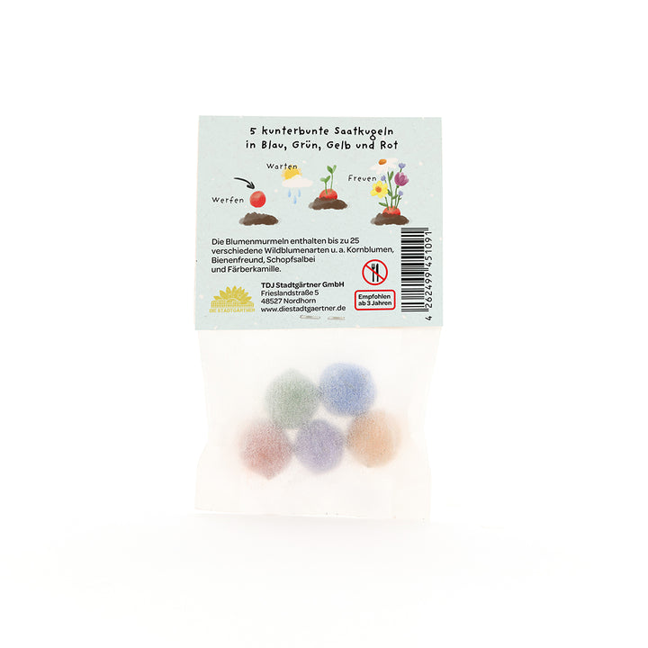 Cinco bolas de semillas de colores en un paquete transparente, con instrucciones e ilustraciones en alemán en la etiqueta.