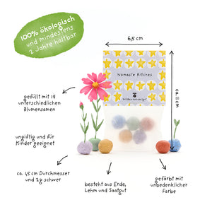 Una bolsa de bolas de semillas de colores, etiquetada con información en alemán sobre el tamaño, los ingredientes, la producción orgánica y la idoneidad para niños, junto con algunas flores florecientes y una marca verde que dice "100% orgánico y dura al menos 2 años".