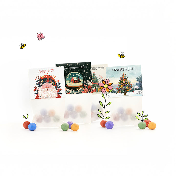 Tres bolsas de regalo con temática navideña con adornos coloridos, motivos navideños ilustrados y las palabras "¡Feliz Navidad!", además de flores dibujadas, abejas y una mariposa.