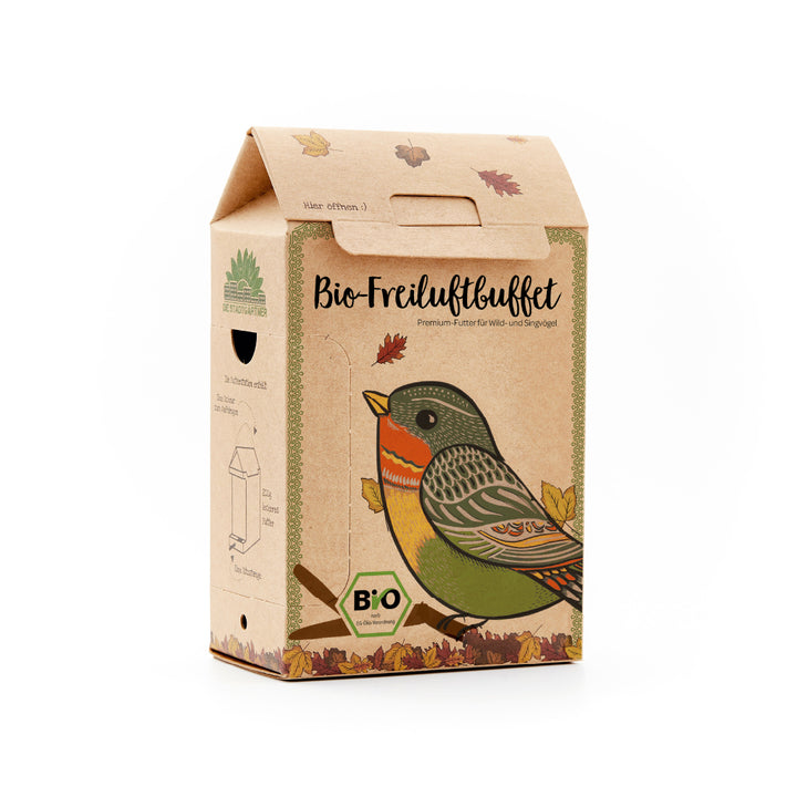 Embalaje de cartón con un colorido dibujo de un pájaro y la inscripción “Organic Outdoor Buffet”, alimento premium para pájaros silvestres y cantores.