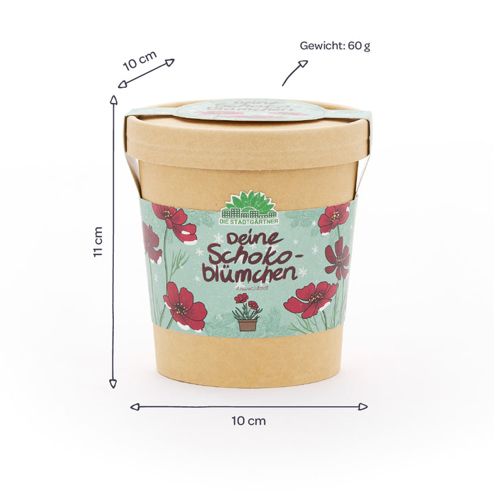 Vaso de papel con motivo de flores y la inscripción “Deine Schokoblümchen”, al lado se indican las dimensiones (10 cm de diámetro, 11 cm de altura) y el peso (60 g) en alemán.