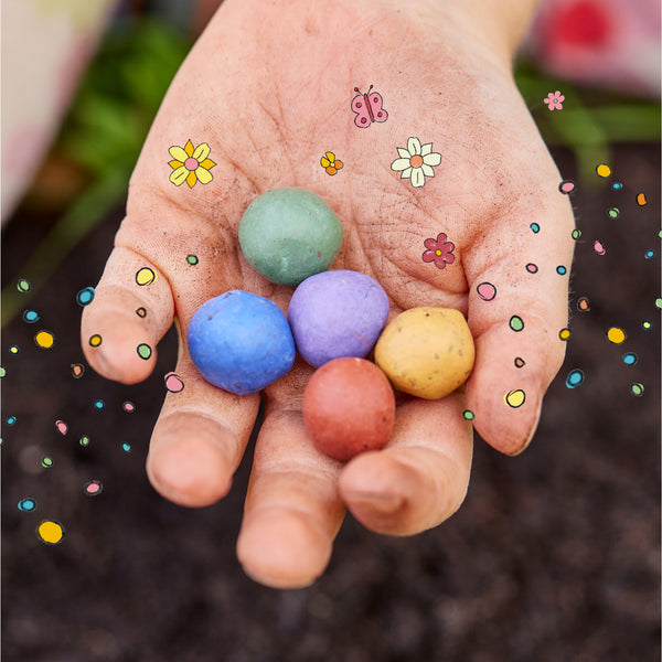 Una mano sosteniendo huevos de tiza de colores rodeados de flores y mariposas dibujadas.
