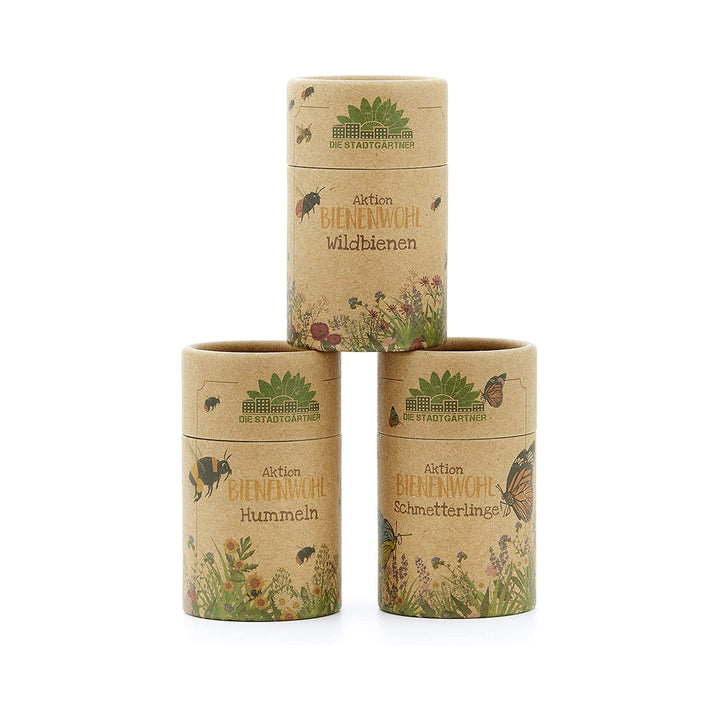 Tres cilindros de cartón con la inscripción 'Aktion Bienenwohl' (Acción por el bienestar de las abejas) para abejas silvestres, abejorros y mariposas de 'Die Stadtgärtner' (Los jardineros urbanos).