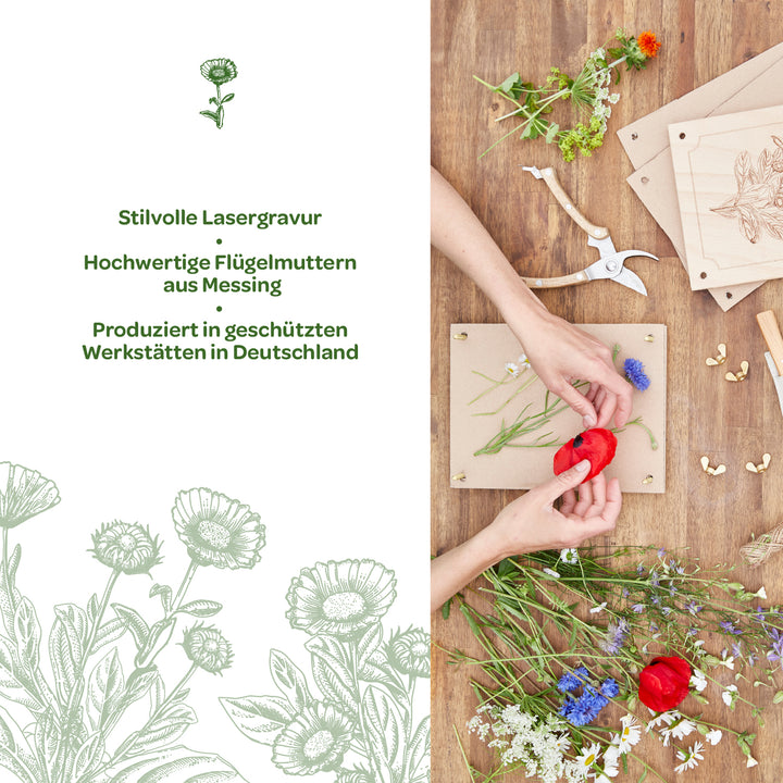 Dos manos colocan flores de colores sobre un marco de madera; junto a él, sobre una mesa de madera, se encuentran herramientas, tuercas de mariposa de latón y placas de madera grabadas. A la izquierda, texto con información sobre el elegante grabado láser y su producción en Alemania.