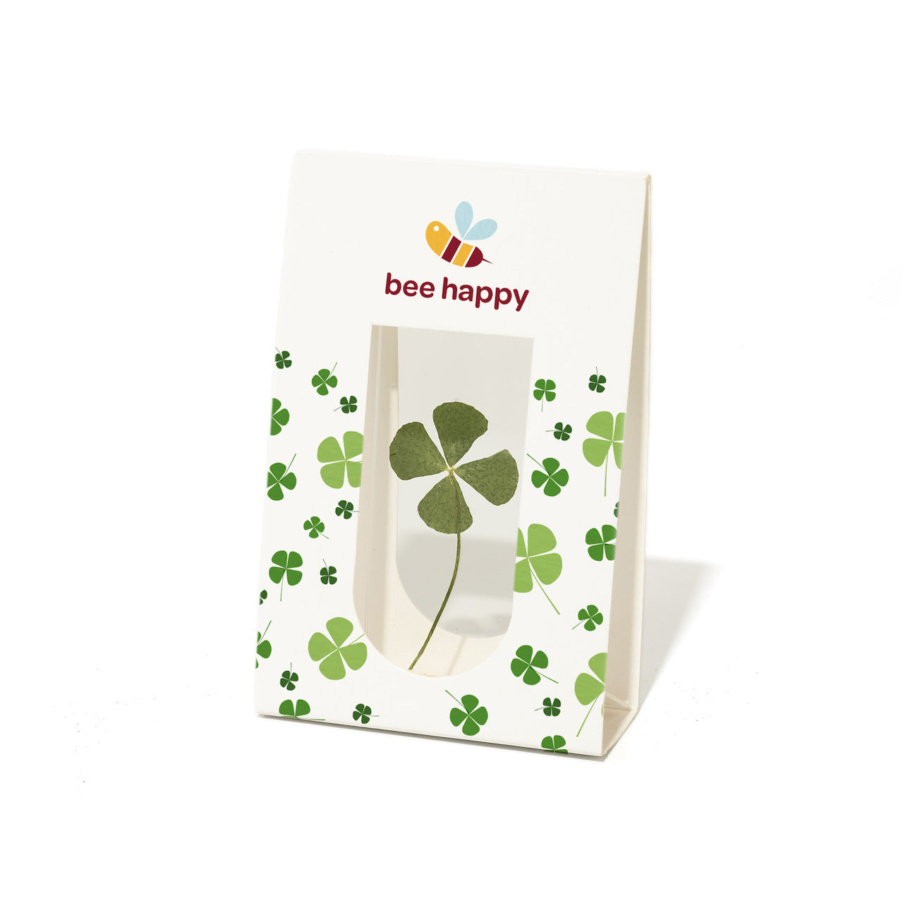 Bolsa de papel con un trébol de cuatro hojas y el texto "bee happy", así como una ilustración de una abeja.