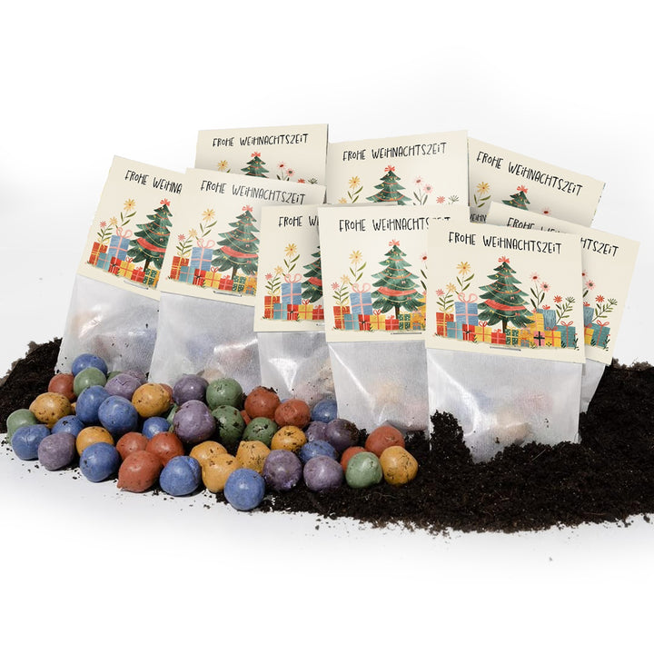 Varias bolsitas de tarjetas navideñas con la inscripción "Feliz Navidad", con bombas de semillas de colores y tierra en primer plano.