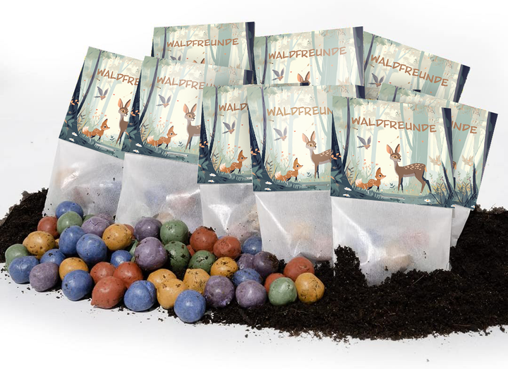 Detrás de bolas de semillas de colores colocadas sobre el suelo se encuentran varias bolsitas con la etiqueta "WALDFREUNDE" (Amigos del bosque) y dibujos de animales del bosque.
