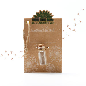 Tarjeta marrón con la inscripción "Los jardineros de la ciudad", una pequeña botella de vidrio y dientes de león ilustrados.