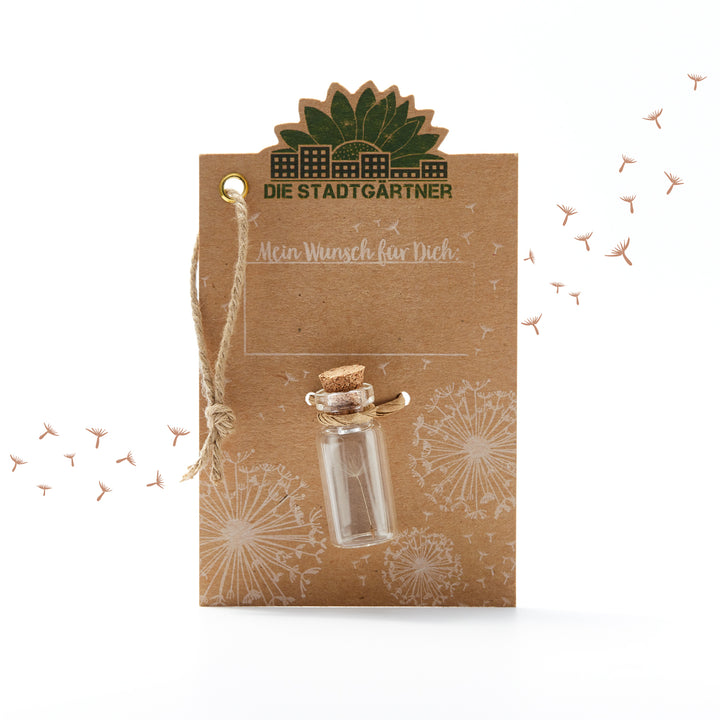 Tarjeta marrón con la inscripción "Los jardineros de la ciudad", una pequeña botella de vidrio y dientes de león ilustrados.