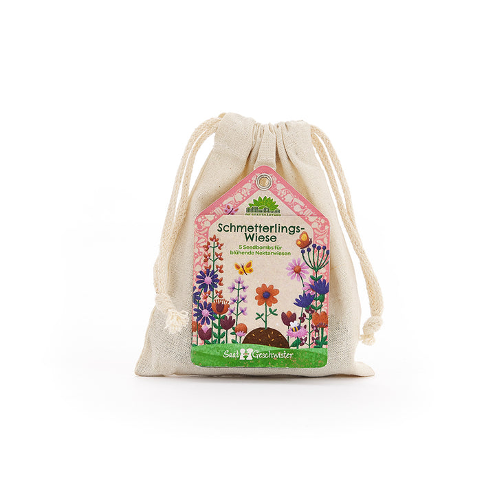 Bolsa de tela de color beige con una etiqueta colorida que representa un "prado de mariposas" y un prado de flores.
