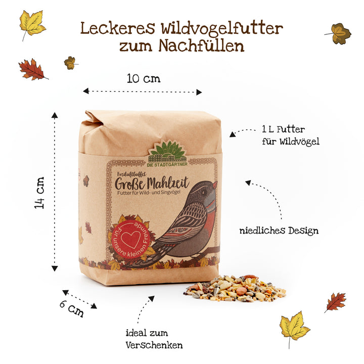 Bolsa de papel que contiene alimento para pájaros silvestres, motivo ilustrado de pájaros y alimento para pájaros esparcido, rodeado de hojas de otoño y etiquetas que indican tamaño y uso.
