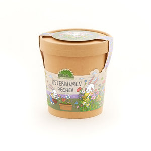 Maceta marrón con coloridas decoraciones de Pascua y la inscripción “Copa de Flores de Pascua”, ilustrada con flores y un conejito.