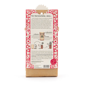 Parte posterior de un paquete con un patrón floral rojo, descripción en texto en alemán e instrucciones para plantar fresas.