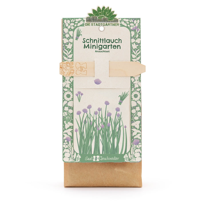 Bolsa de papel con kit para cultivar cebollino, ilustrada con motivos vegetales verdes y morados y etiqueta de madera, de Die Stadtgärtner.