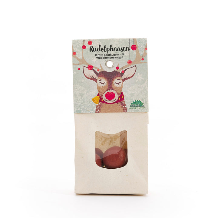 Bolsa de papel con estampado de renos y el texto "Narices de Rudolph: 8 bolas de semillas rojas con semillas de flores silvestres", con una ventana de visualización que contiene bolas de semillas rojas debajo.