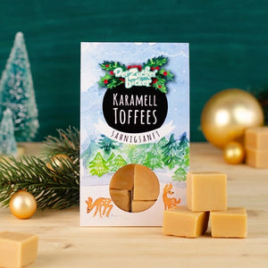 Pack de toffees de caramelo con adornos navideños y rama de abeto.