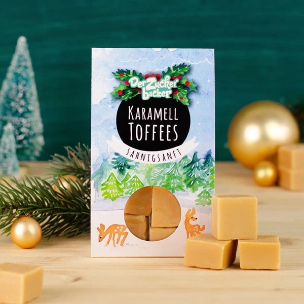 Pack de toffees de caramelo con adornos navideños y rama de abeto.