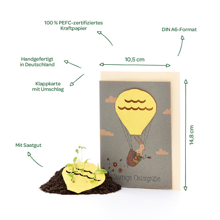 Tarjeta plegable con sobre en formato DIN A6, hecha a mano en Alemania con papel kraft 100% certificado PEFC, incluye semillas y un motivo de un conejo en un globo aerostático; las dimensiones y características están etiquetadas.