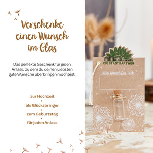 Imagen publicitaria para el concepto de regalo "Wish in a Jar" con texto, un vaso sobre una tarjeta y flores secas de fondo.