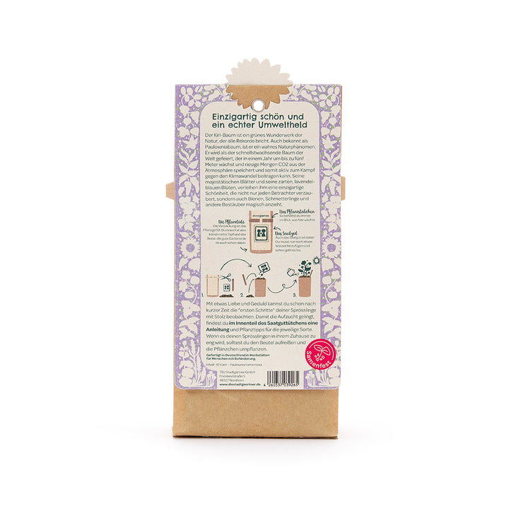 Parte posterior de un paquete con un patrón floral de color violeta, texto sobre el respeto al medio ambiente del árbol Kiri, instrucciones de plantación y el logotipo del Festival de Semillas en la parte inferior derecha.