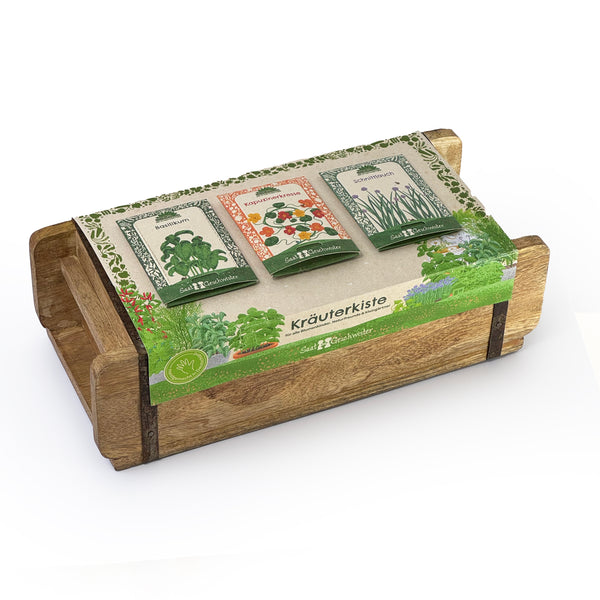 Caja de madera con tres paquetes de semillas de hierbas (albahaca, capuchina, cebollino) y la inscripción "Kräuterkiste" (Caja de hierbas) en una banderola.