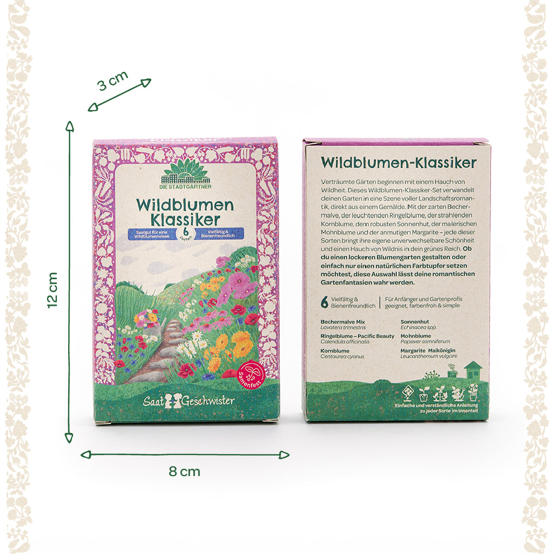 Dos cajas de semillas diseñadas en colores vivos con la inscripción "Wildflower Classics" de Die Stadtgärtner, que incluyen información sobre el tamaño (12 cm de alto, 8 cm de ancho, 3 cm de profundidad) e ilustraciones de flores en el frente.
