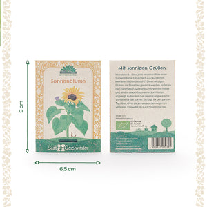 Dos paquetes de semillas de girasol de la marca "SaatGeschwister" con dimensiones visibles por delante y por detrás; por delante con ilustración de girasol, por detrás con texto descriptivo y código de barras.