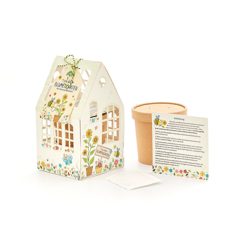 Kit de manualidades para jardín de flores con casa decorativa, maceta, paquete de semillas e instrucciones en alemán.
