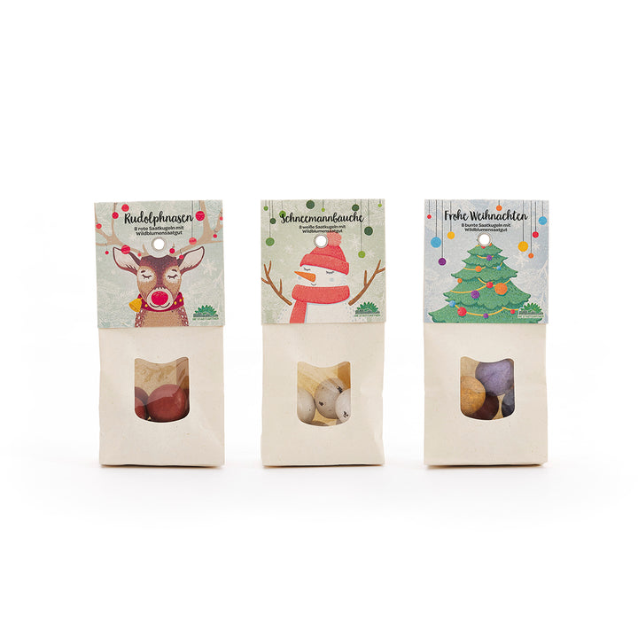 Tres bolsas navideñas de dulces decoradas con ilustraciones de un reno, un muñeco de nieve y un árbol de Navidad.